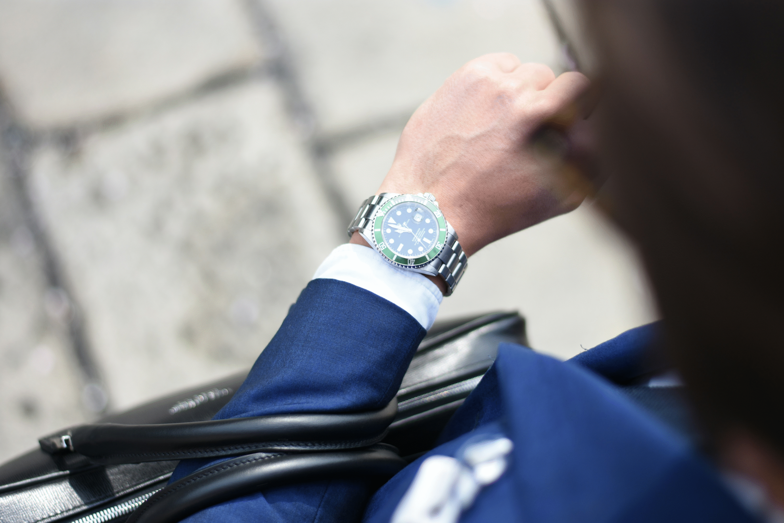 A close-up of a well-dressed professional's wrist with a watch, symbolizing precision, timeliness, and the dedicated expertise of About Management Loop.