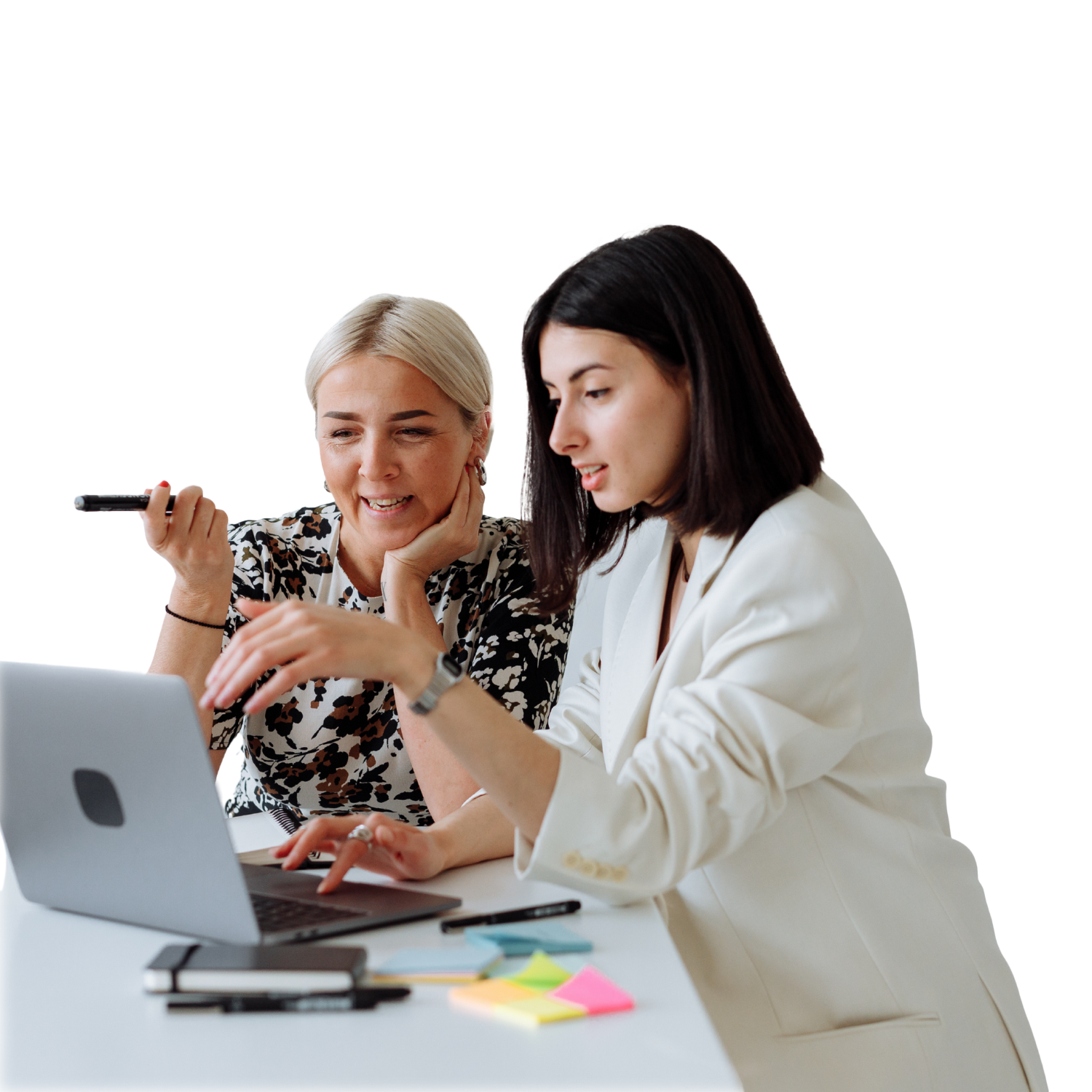 An older businesswoman with blonde hair and a younger businesswoman with dark hair are collaborating on a laptop, a good visual for HR training, business women or mentorship programs.