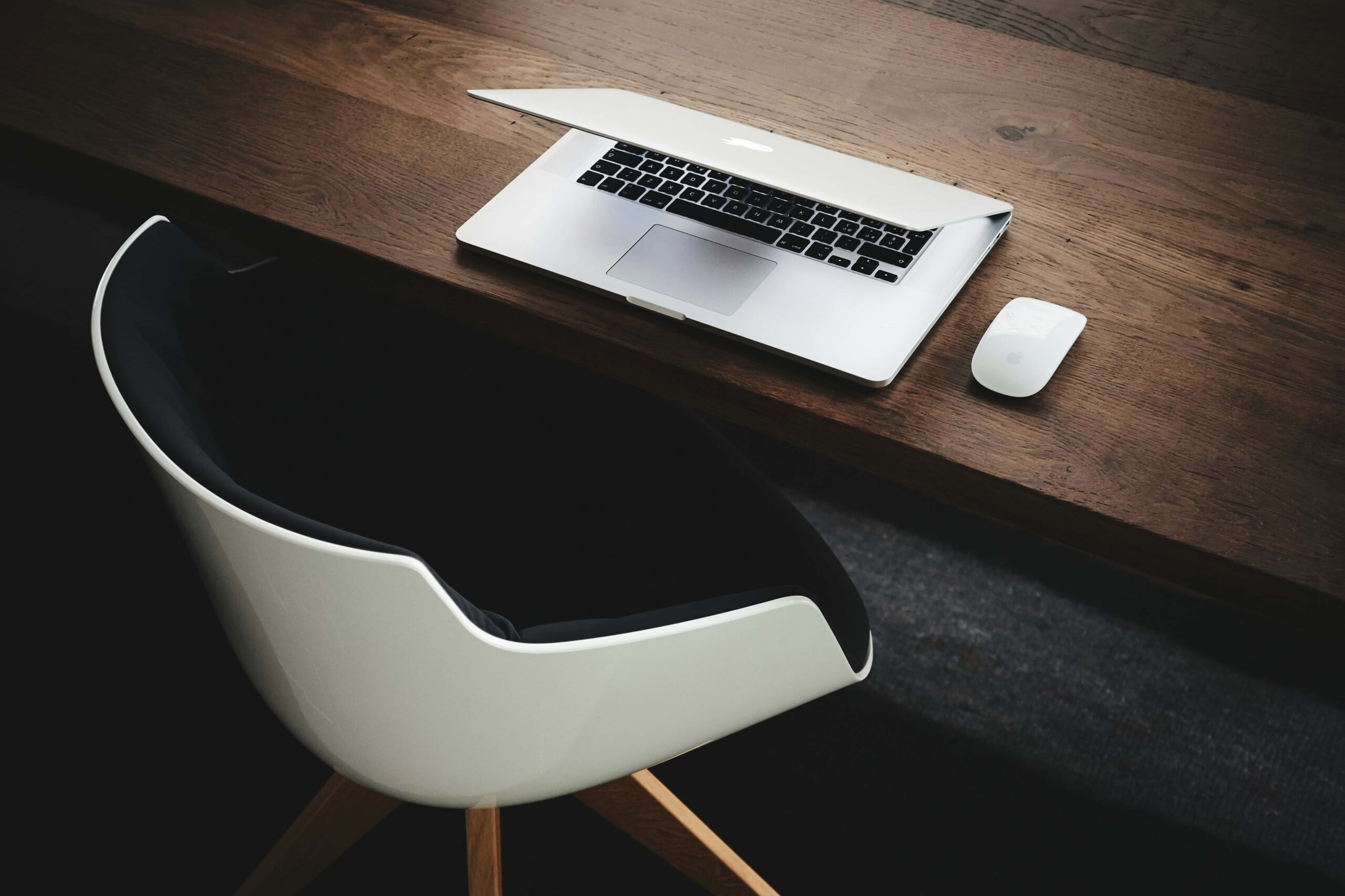 A professional desk setup with a laptop and a chair, ideal for representing remote work, business plan creation, or a modern office environment.